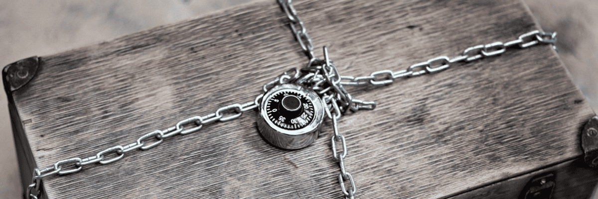 Vintage wooden chest secured with chains and a combination padlock.