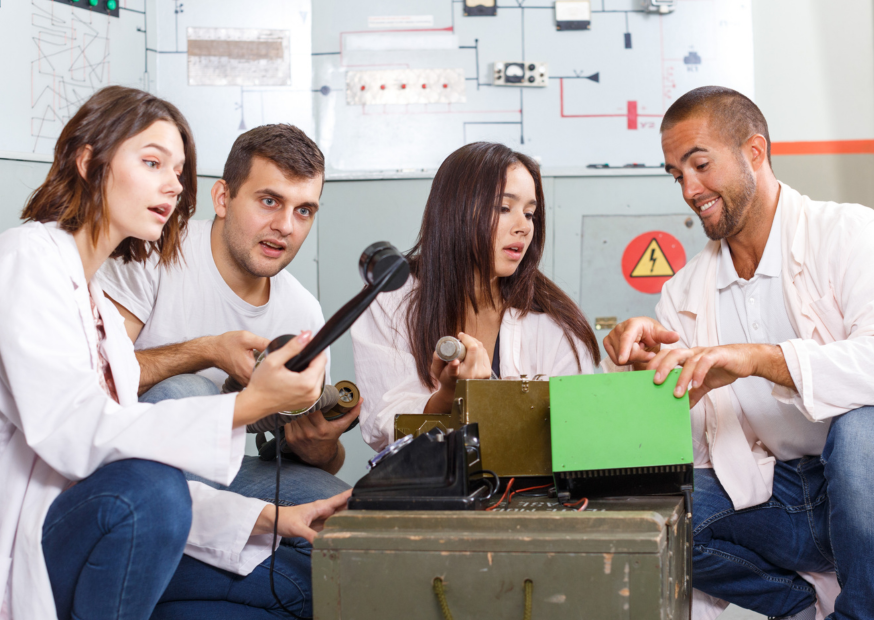 a (6) Team of players solving a science-themed escape room challenge inside a laboratory